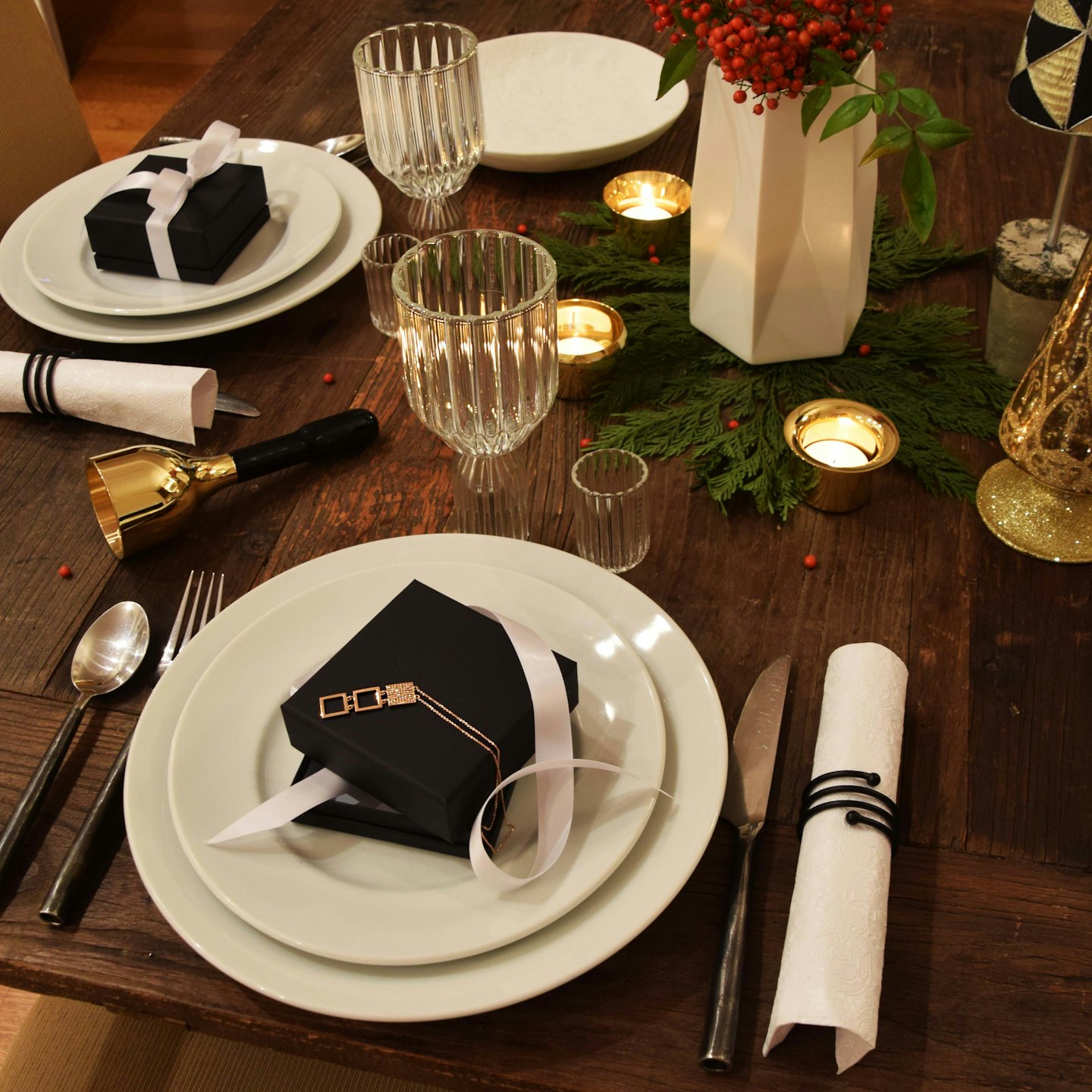Festlich gedeckter Tisch mit Geschenken und Weihnachtsdekoration auf Holzoberfläche.