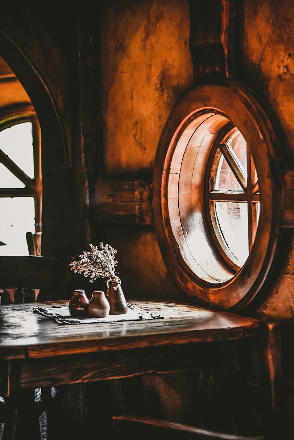 Keramikvasen und Trockenblumen stehen auf einem Holztisch.